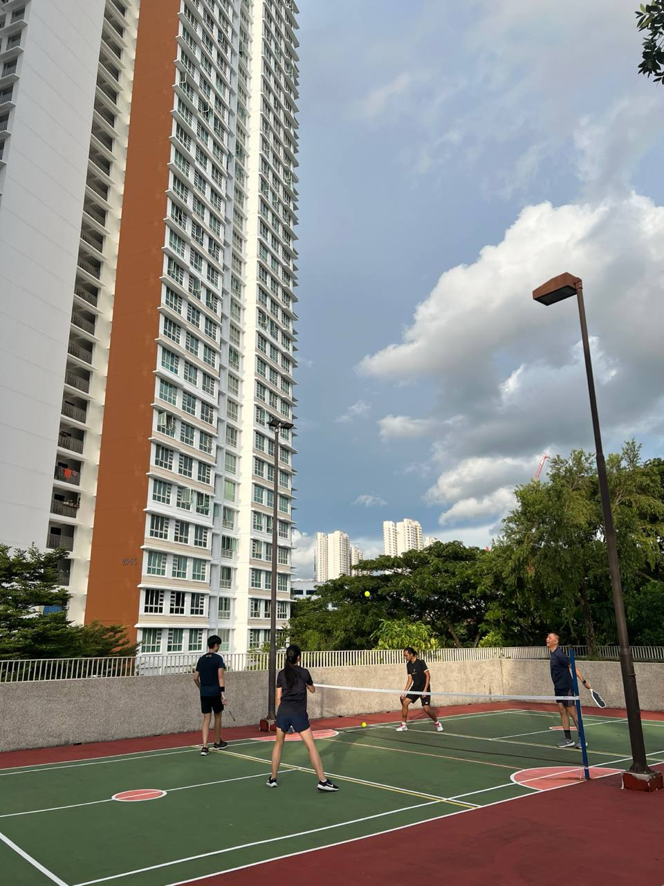 Four recreational pickleball players during a daytime court session
