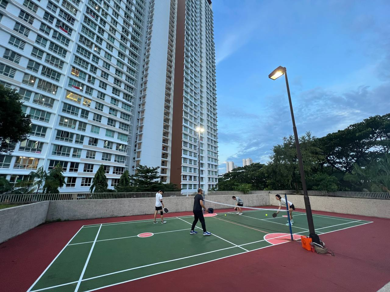 Small-group pickleball practice during an evening session